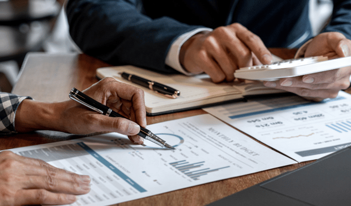 Businessmen calculating and reading charts